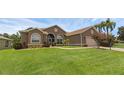 Inviting exterior with lush lawn, palm trees, and well-maintained landscaping at 4826 Sable Ridge Ct, Leesburg, FL 34748