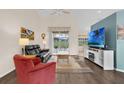 Cozy living room featuring a high ceiling, ceiling fan, and sliding glass doors at 4826 Sable Ridge Ct, Leesburg, FL 34748