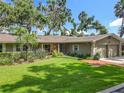 Charming single-story home with lush landscaping and a well-maintained lawn at 504 Banning Beach Rd, Tavares, FL 32778