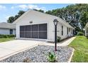 Exterior of a one-story home featuring a screened-in garage, a small lightpost, and rock features at 5507 Laver St, Leesburg, FL 34748