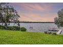 A serene view of the waterfront from the lush green backyard of the property at 6136 Lake Emma Rd, Groveland, FL 34736