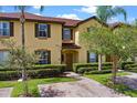A delightful townhouse with a brick driveway, lush shrubs, and palm trees at 624 Terra Lago St, Davenport, FL 33897