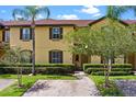 Charming two-story townhome with manicured shrubs and palm trees at 624 Terra Lago St, Davenport, FL 33897