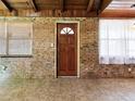 Inviting entryway with brick walls, wood accents, and a door with glass detailing, offering a warm welcome at 6731 Lake Griffin Rd, Lady Lake, FL 32159