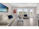 Bright living room featuring modern sofas, tile floors, and large windows at 709 Longboat Dr, Davenport, FL 33896