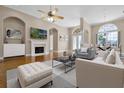 Bright living room with fireplace, elegant furniture, high ceilings, and archway to dining area at 7303 Spring Mountain Ln, Yalaha, FL 34797