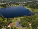 Expansive view showcasing a serene lake surrounded by lush greenery and homes, creating a peaceful neighborhood setting at 81 N Carol Ave, Mascotte, FL 34753