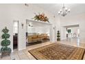 Bright living area with soaring ceilings, tile flooring, neutral walls, and open access to connected rooms at 81 N Carol Ave, Mascotte, FL 34753