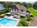 Backyard pool area featuring a sparkling pool, patio furniture, and lush landscaping at 9233 Silver Lake Dr, Leesburg, FL 34788
