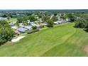 An aerial shot displays a vast golf course surrounded by charming homes and lush trees at 926 Saint Andrews Blvd, Lady Lake, FL 32159
