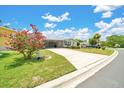 Charming home featuring a long driveway, covered carport, and mature landscaping with a beautiful crape myrtle tree at 926 Saint Andrews Blvd, Lady Lake, FL 32159