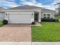 Well-maintained single-story home featuring a brick-paved walkway and lush green lawn at 9380 La Salle St, Groveland, FL 34736
