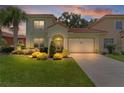 Charming two-story home with a well-manicured lawn, lush landscaping, and a two-car garage at 1055 Avenida Sonoma, Lady Lake, FL 32159
