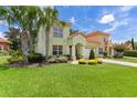 Charming two-story home with a well-manicured lawn, lush landscaping, and a two-car garage at 1055 Avenida Sonoma, Lady Lake, FL 32159
