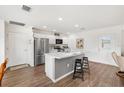 Bright kitchen featuring a stainless steel refrigerator and a cozy breakfast bar with seating at 1309 Lester Dr, The Villages, FL 32159