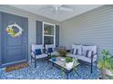 Inviting outdoor porch with comfortable seating, stylish decor, and a ceiling fan for a relaxing ambiance at 1478 Erika Pl, The Villages, FL 32163