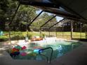 Enclosed pool with a bench and lots of pool toys at 2108 Dogwood Cir, Mount Dora, FL 32757