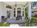 Inviting front porch with comfortable seating, elegant arched windows, and lush landscaping at 2512 Baywater Rd, Tavares, FL 32778