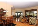 Open-concept living room boasts natural light, hardwood floors, and tropical-themed decor at 27328 Pine Straw Rd, Leesburg, FL 34748