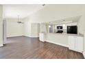 Open-concept living area with vaulted ceilings and wood-look floors, adjoining a modern kitchen at 2815 Spyglass Cv, Longwood, FL 32779