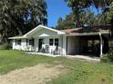 Cozy single-story home with classic black shutters, a comfortable front porch, and a practical attached carport at 32511 Purdum Ave, Leesburg, FL 34788