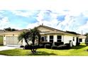 Inviting home featuring a well-maintained lawn, mature landscaping, and attached two car garage at 327 Bentwood Dr, Leesburg, FL 34748