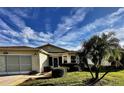 Charming home with manicured lawn, vibrant landscaping, and inviting front entrance at 327 Bentwood Dr, Leesburg, FL 34748