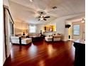 Bright living room features hardwood floors, comfortable seating, and an open layout with backyard access at 327 Bentwood Dr, Leesburg, FL 34748