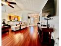 Cozy living room showcasing hardwood floors, comfortable armchair, and a view of the kitchen at 327 Bentwood Dr, Leesburg, FL 34748