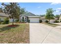 Inviting single-story home showcasing a well-maintained lawn and an attached two-car garage at 33441 Irongate Dr, Leesburg, FL 34788