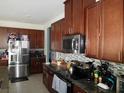 Elegant kitchen featuring stainless steel appliances, granite counters, and ample dark wood cabinetry at 418 Winter Bliss Ln, Mount Dora, FL 32757