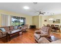 Bright living room featuring hardwood floors, ceiling fan, and sliding door access to the outdoors at 4909 Kelso St, Leesburg, FL 34748