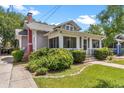 Charming bungalow with a screened front porch, red chimney, and manicured landscaping at 501 Washington Ave, Eustis, FL 32726