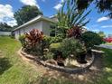 Well maintained front yard with flowering bushes around the perimeter of the home at 15509 Markham Dr, Clermont, FL 34714