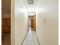 Hallway with tile flooring and natural wood trim connecting different areas of the house at 1053 Cavern Dr, Apopka, FL 32712