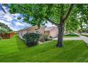 Well-manicured lawn surrounding the house, mature tree in front of home at 1055 Bluegrass Dr, Groveland, FL 34736