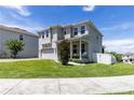 Side view of a two-story home featuring a welcoming porch, tidy lawn, and a two-car garage at 1131 Dora Parc Ln, Mount Dora, FL 32757
