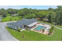 Expansive aerial view of the property showcasing the pool, outdoor living space, and lush green surroundings at 14227 County Road 455, Clermont, FL 34711