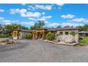 Beautiful exterior of the home showcasing the gray stone, well-manicured landscaping, and wood accents at 14227 County Road 455, Clermont, FL 34711