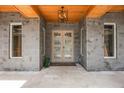 Close-up of the front door featuring stone accents, a modern light fixture, and a welcoming entrance at 14227 County Road 455, Clermont, FL 34711