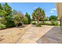 Beautifully landscaped backyard features lush greenery, decorative rock, and a stone-paved patio at 1509 Trenton Ln, The Villages, FL 32162