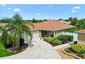 Charming single-story home with a well-manicured lawn, mature landscaping, and a spacious driveway at 1509 Trenton Ln, The Villages, FL 32162
