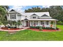 Beautiful home with a metal roof, large front yard, and a covered porch with seating at 15104 County Road 48, Astatula, FL 34705