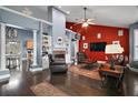 Spacious living room with dark wood floors, a fireplace, and comfortable leather seating at 15104 County Road 48, Astatula, FL 34705