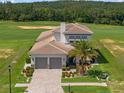 Stunning home exterior with tile roof, paver driveway, landscaping, and a golf course view at 16030 Vetta Dr, Bella Collina, FL 34756