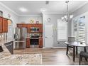 Well-lit kitchen featuring stainless steel appliances, wood cabinets, granite countertops, and a cozy breakfast nook at 16863 Se 110Th Court Rd, Summerfield, FL 34491