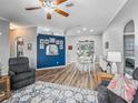 Inviting living room with wood floors, a decorative accent wall, and an open layout for seamless entertaining at 16863 Se 110Th Court Rd, Summerfield, FL 34491