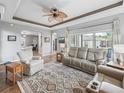 Bright and airy living room showcasing tray ceilings, comfortable seating, and expansive sliding glass doors at 16863 Se 110Th Court Rd, Summerfield, FL 34491