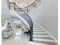 Bright foyer with winding staircase and elegant marble floors at 1702 Hidden Palms Dr, Davenport, FL 33897