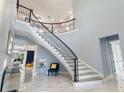 Bright foyer with winding staircase and elegant marble floors at 1702 Hidden Palms Dr, Davenport, FL 33897
